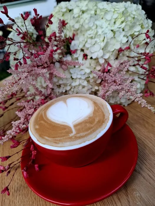 Cappuccino s latte art srdcem v červeném šálku